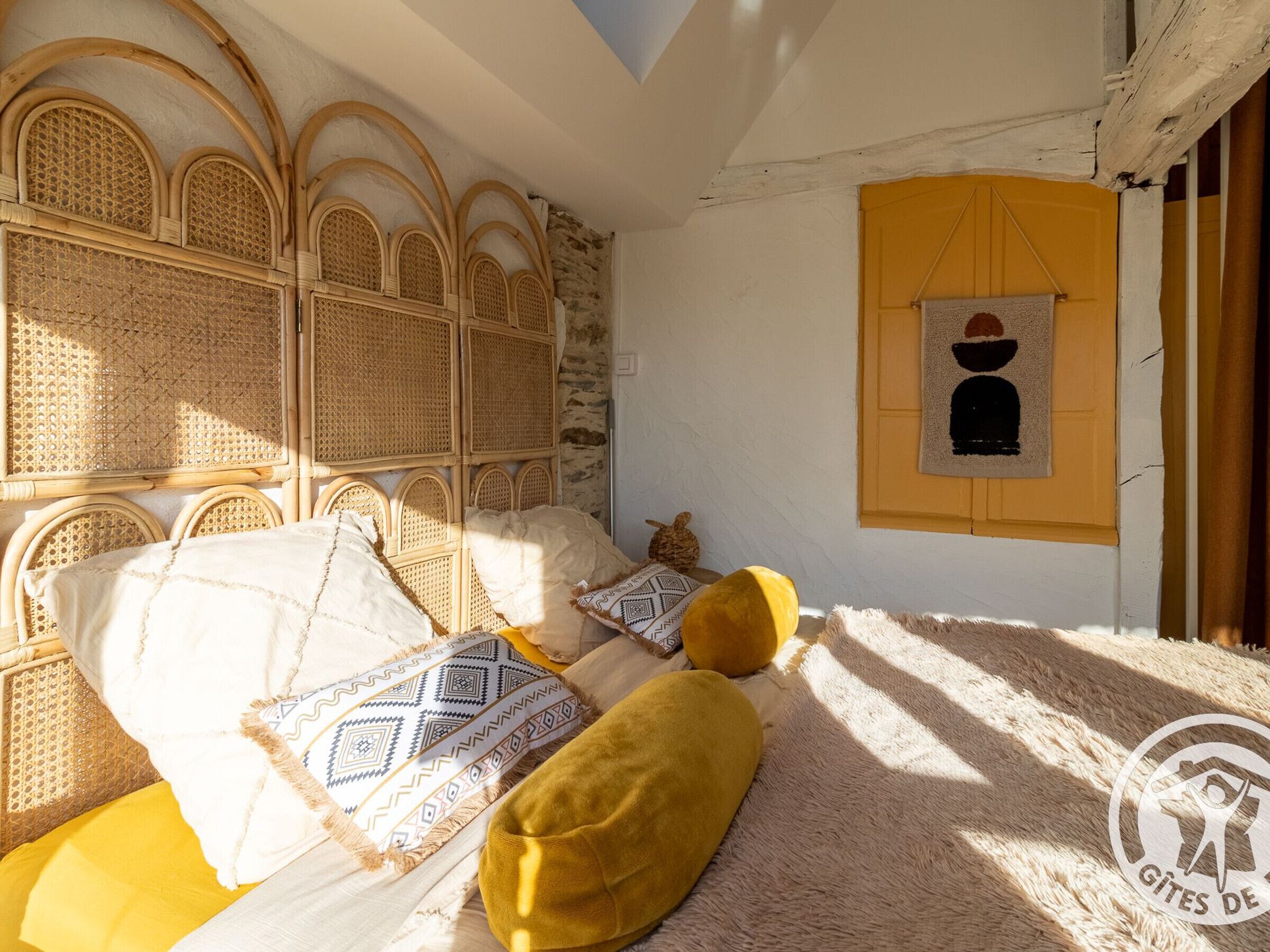 Ein Zimmer mit einem Bett, einem Wandbild und einem Fenster mit Blick nach außen.