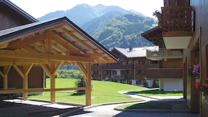 A wooden building with a covered patio area and a view of a mountain. - Renovated apartment with pool in Samoëns (Samoëns)