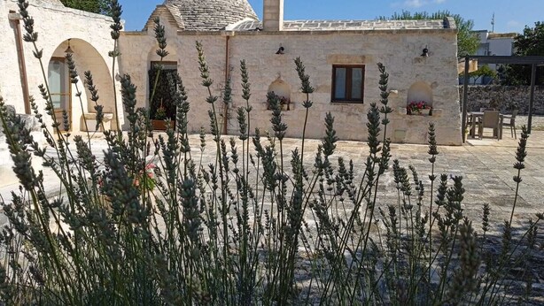 A building with a stone facade, a conical roof, and a small window. - Trulli of the Chain (Martina Franca)