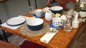 A dining table set with blue and white dishes, a pitcher, a glass of water, and a vase with flowers.