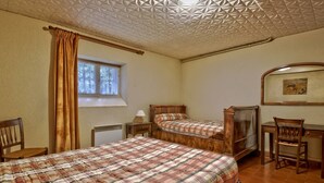 Ein Schlafzimmer mit zwei Betten, einem Fenster, einem Schreibtisch und einem Stuhl.