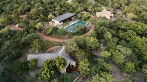 An aerial view of a secluded, tree-lined property with a central building, a swimming pool, and a thatched-roof structure. - Taru Villas Villu - Willpattu (Eluwankulama)