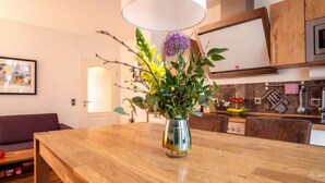 Una mesa de cocina de madera con un florero de flores.