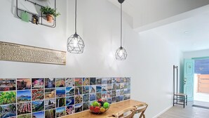 Un comedor con una mesa de madera, sillas y una pared de fotos.