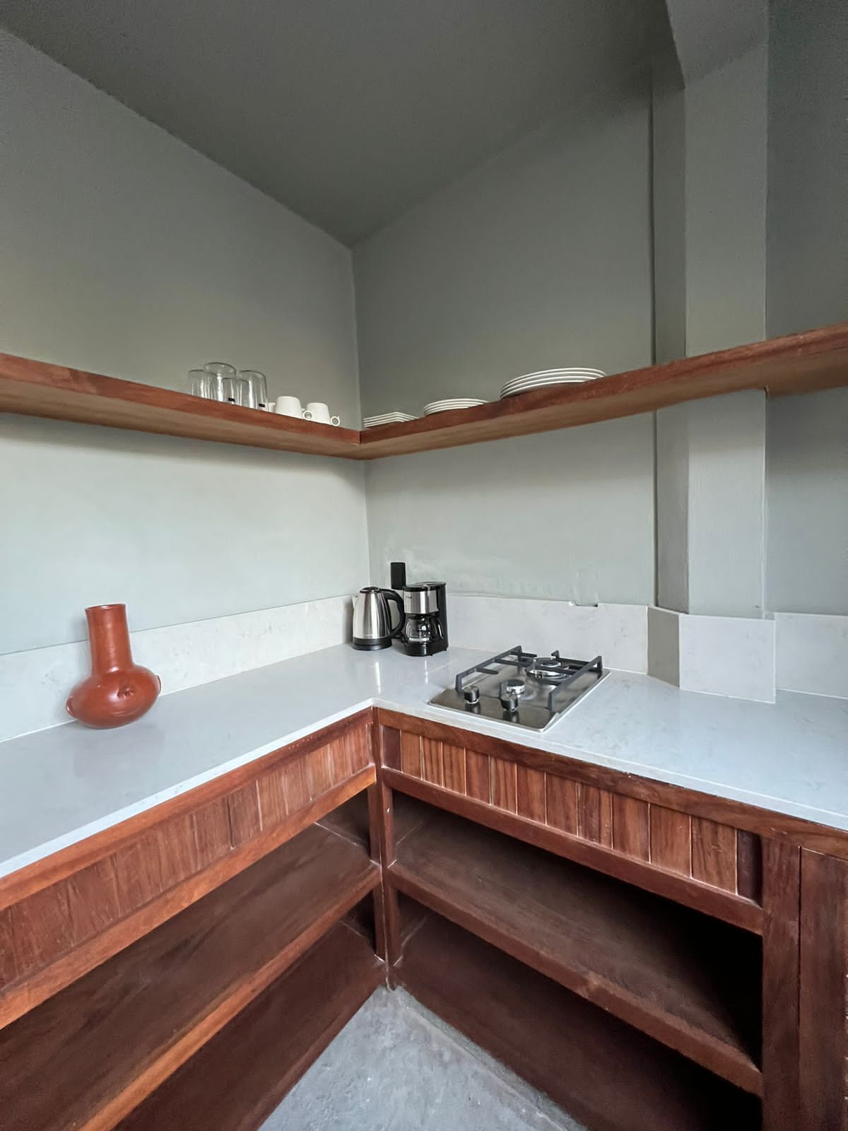 A kitchen with a white countertop, wooden cabinets, and a gas stove.