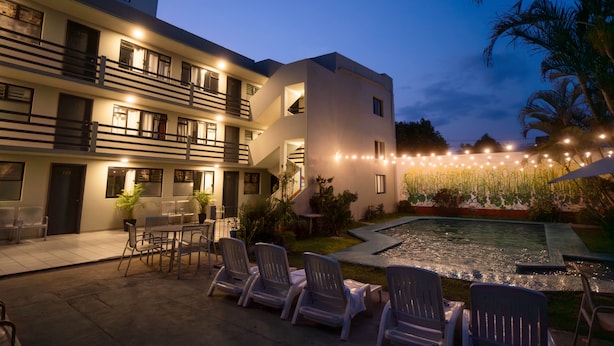 A hotel with outdoor seating, a swimming pool, and string lights. - Lofts Marques Oaxaca (Oaxaca)