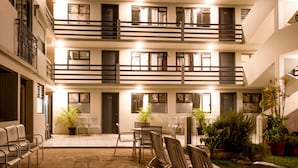 A multi-story hotel with balconies, a courtyard with seating, and potted plants. - Lofts Marques Oaxaca (Oaxaca)