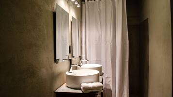 A bathroom with two sinks, a mirror, and a shower curtain.