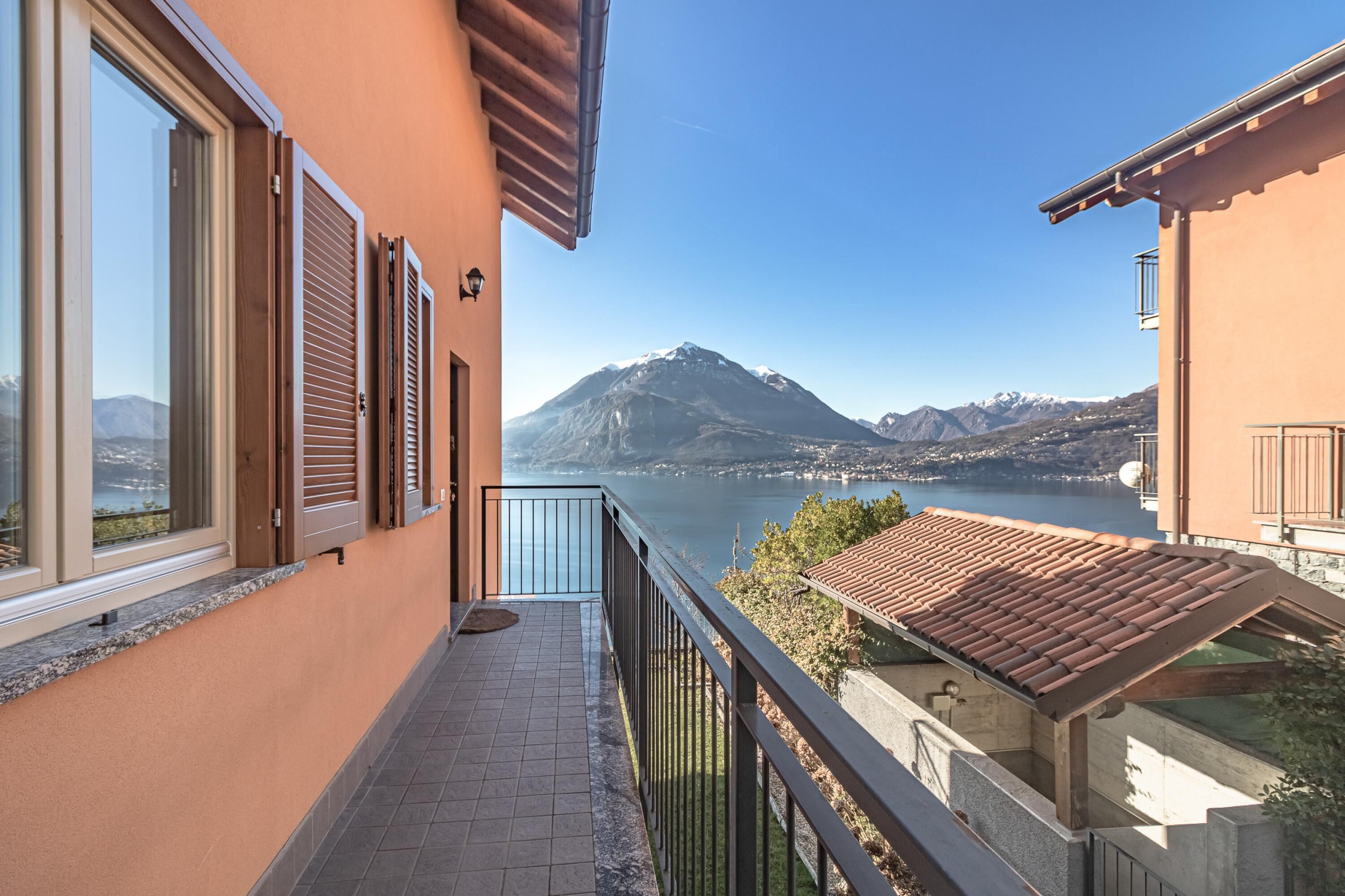 A balcony with a view of a lake and mountains.