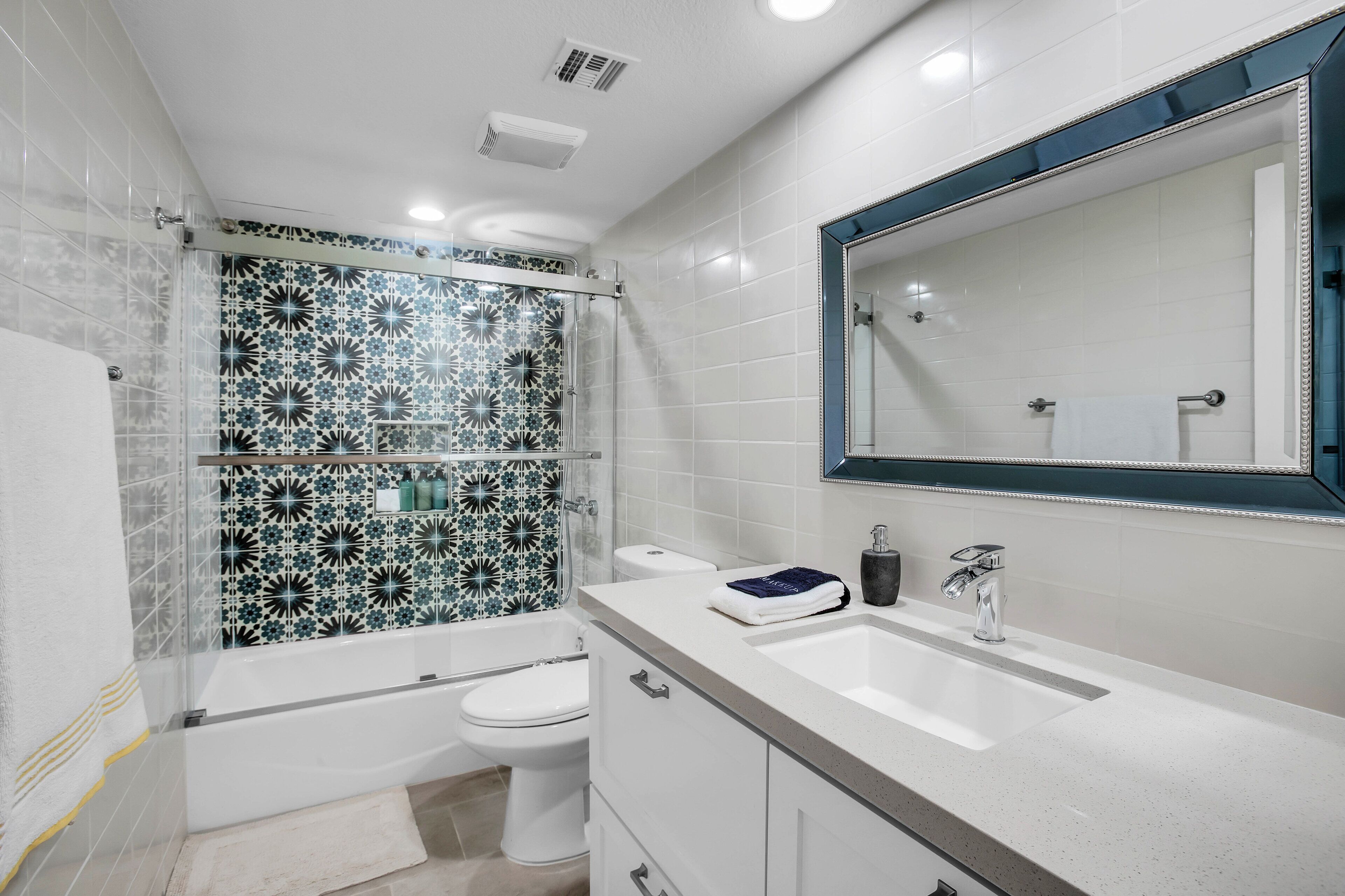 A modern bathroom with a shower, toilet, and sink.