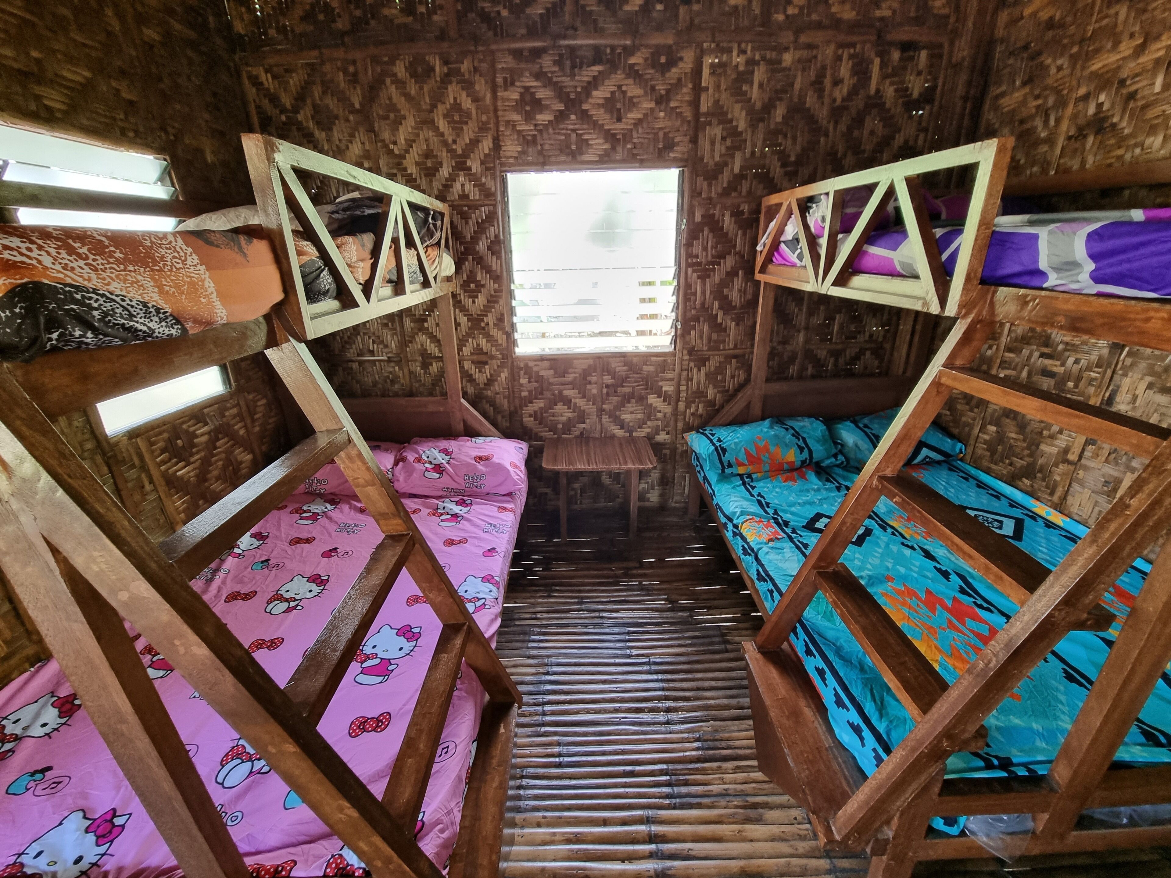 Una habitación con dos literas, una con una colcha rosa de Hello Kitty y la otra con una colcha azul estampada.