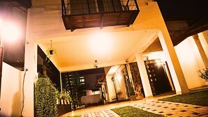 A building with a balcony, a covered entrance, and a well-lit pathway. - Ared Villa (Seeduwa - Katunayake)