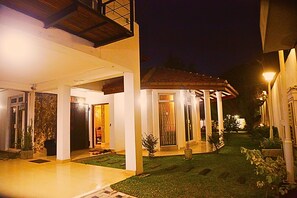 Una casa moderna con patio coperto, prato curato e ingresso carrabile.