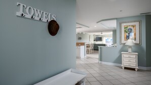 A modern kitchen with white cabinets, a central island, and a dining area with chairs.