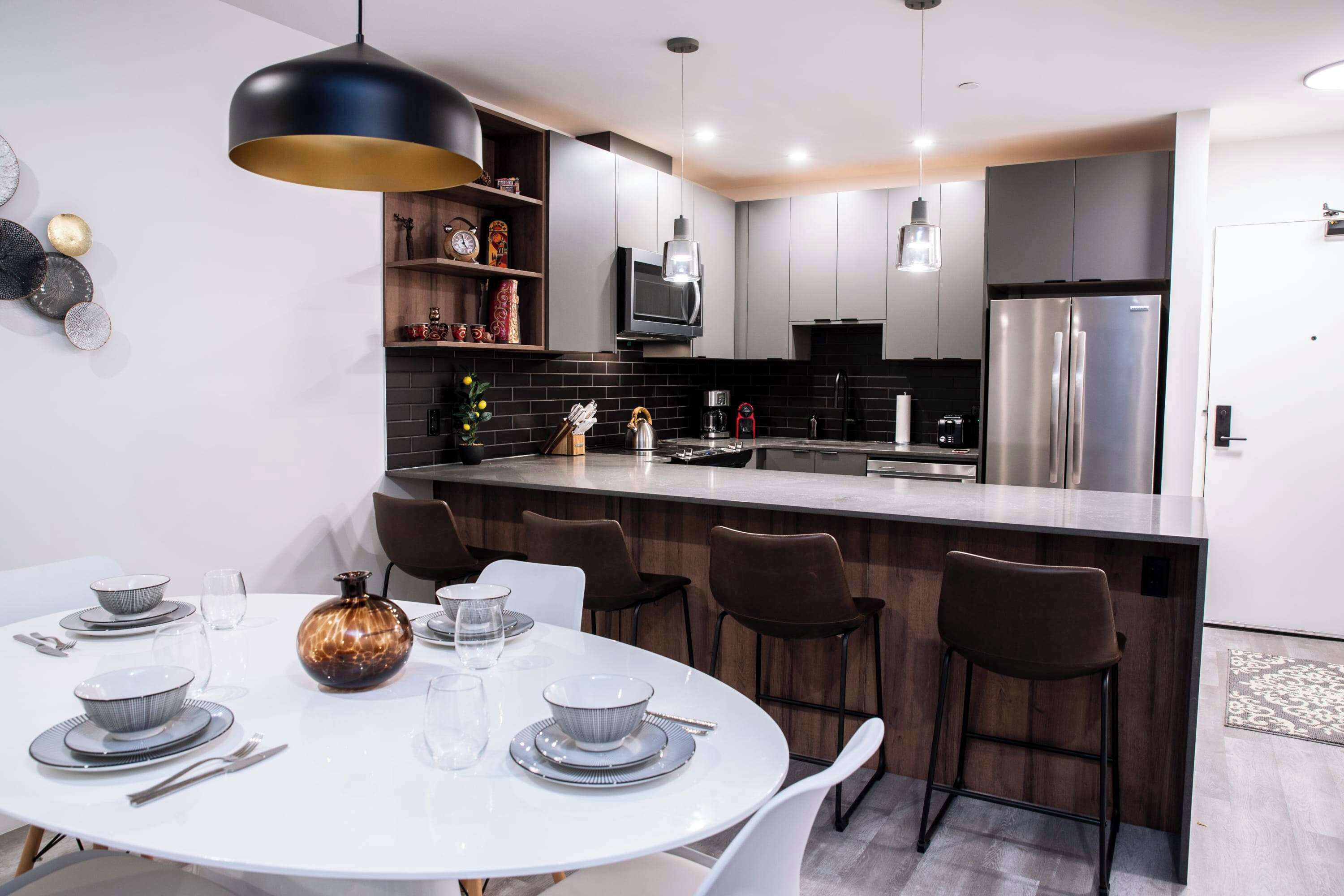 Una cocina moderna con una isla central, armarios de madera oscura y un horno empotrado.