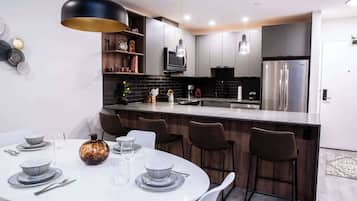 Una cocina moderna con una isla central, armarios de madera oscura y un horno empotrado.