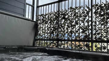 Una habitación con un ventanal grande, una barandilla metálica y vistas a un edificio.