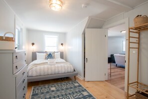 A bedroom with a bed, a dresser, a window, and a door leading to another room. - 5 Min. Drive to Fisher Beach and Pamet Harbor! (Truro)