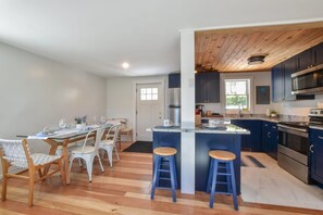 A modern kitchen with dark blue cabinets, a stainless steel refrigerator, and a built-in oven. - 5 Min. Drive to Fisher Beach and Pamet Harbor! (Truro)