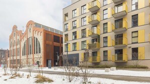 A modern building with a mix of architectural styles, including a section with large windows and another with balconies. - Modern Apartment | 2 Bedrooms | Parking. (Lódz)