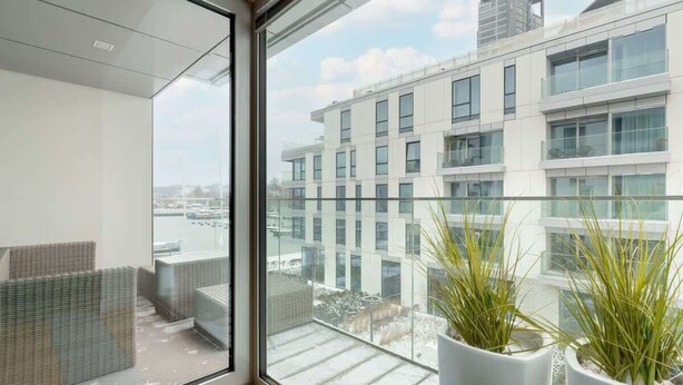 Un apartamento moderno con un amplio ventanal que da a un paisaje urbano.