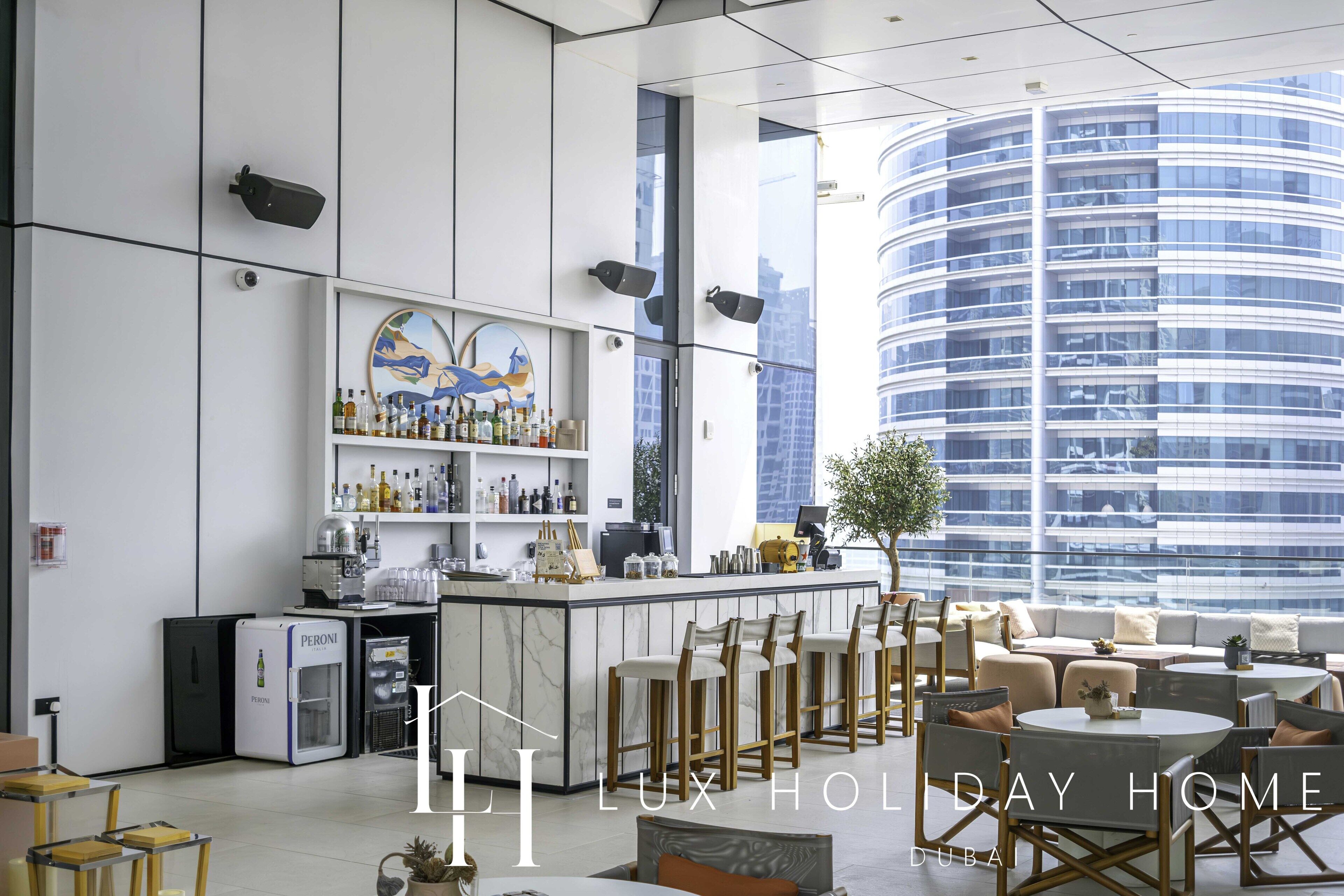 Eine moderne Hotelhalle mit Bar, Sitzgelegenheiten und Blick auf ein Hochhaus.