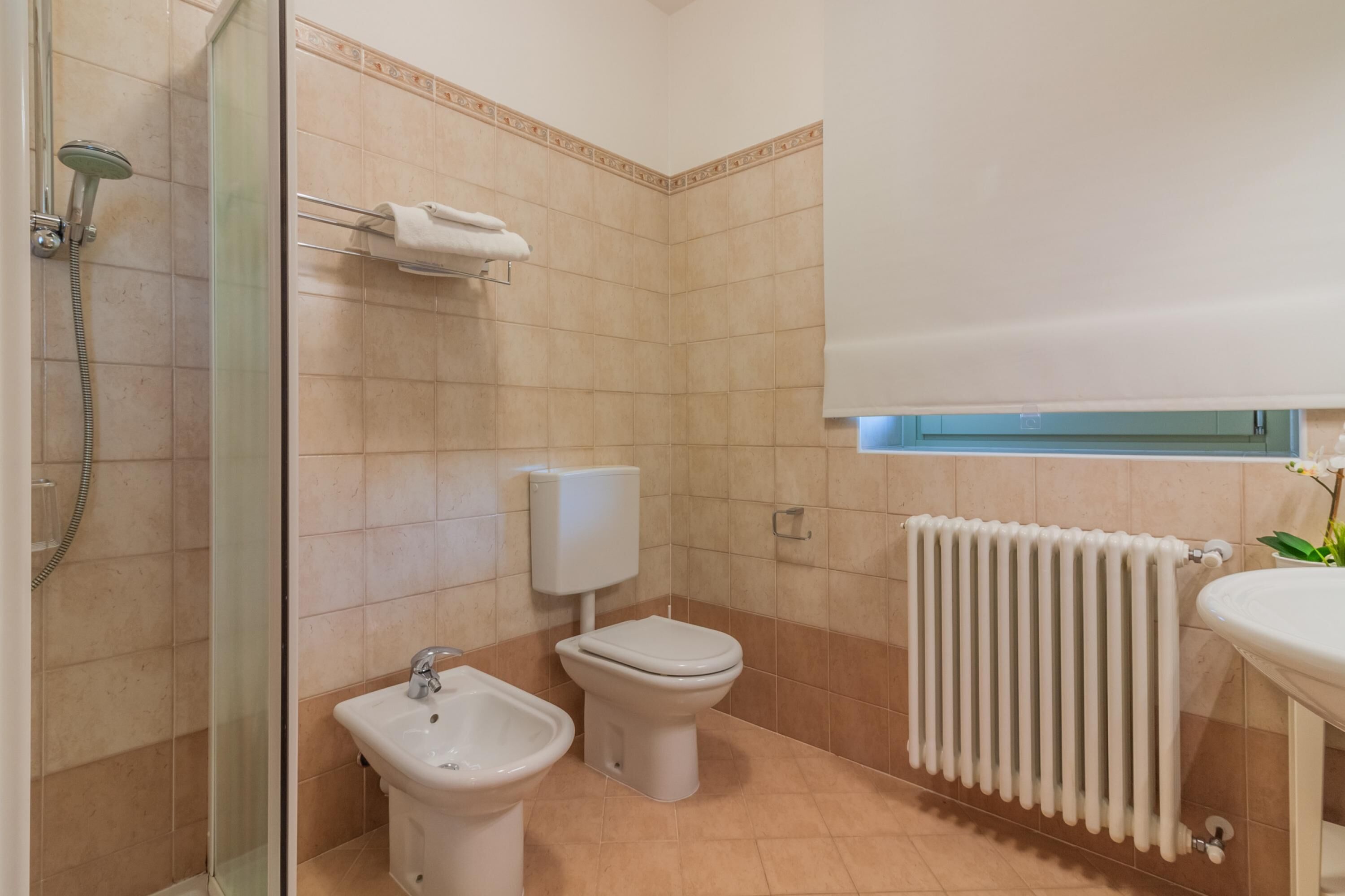Un bagno con doccia, bidet, wc e lavandino.
