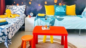 A child's bedroom with a bed, a small table, and a chair.
