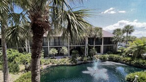 A pool area with palm trees and a building in the background. - Beach getaway overlooking tropical lagoon. (Saint Augustine)