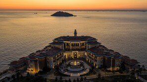 A waterfront hotel with a central courtyard, multiple balconies, and a view of the sea. - Birun Ada Hotel (Adalar)
