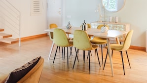 A dining area with a wooden table and chairs, a mirror, and a staircase. - Elegant apartment with patio at Piazza Navona (Roma)