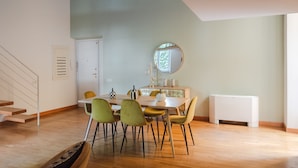 A dining area with a table, chairs, a mirror, and a radiator. - Elegant apartment with patio at Piazza Navona (Roma)
