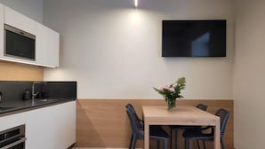 A modern kitchen with white cabinets, a black countertop, and a built-in oven. - Magnolia LevicoGround floor apartment in the center of Levico Terme (Levico Terme)