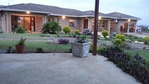A two-story house with a brick exterior, a front porch, and a well-maintained garden with various plants and shrubs.