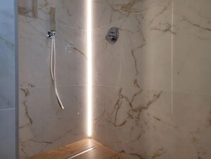 Een douche, een haardroger, een bidet, handdoeken