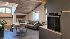 A modern kitchen with a built-in oven and a dining area with a table and chairs.