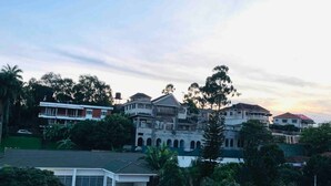 A residential area with multiple houses, including a large house with a balcony and a smaller house with a garage. - IvyRose Luxury Apartment 1 (Kampala)