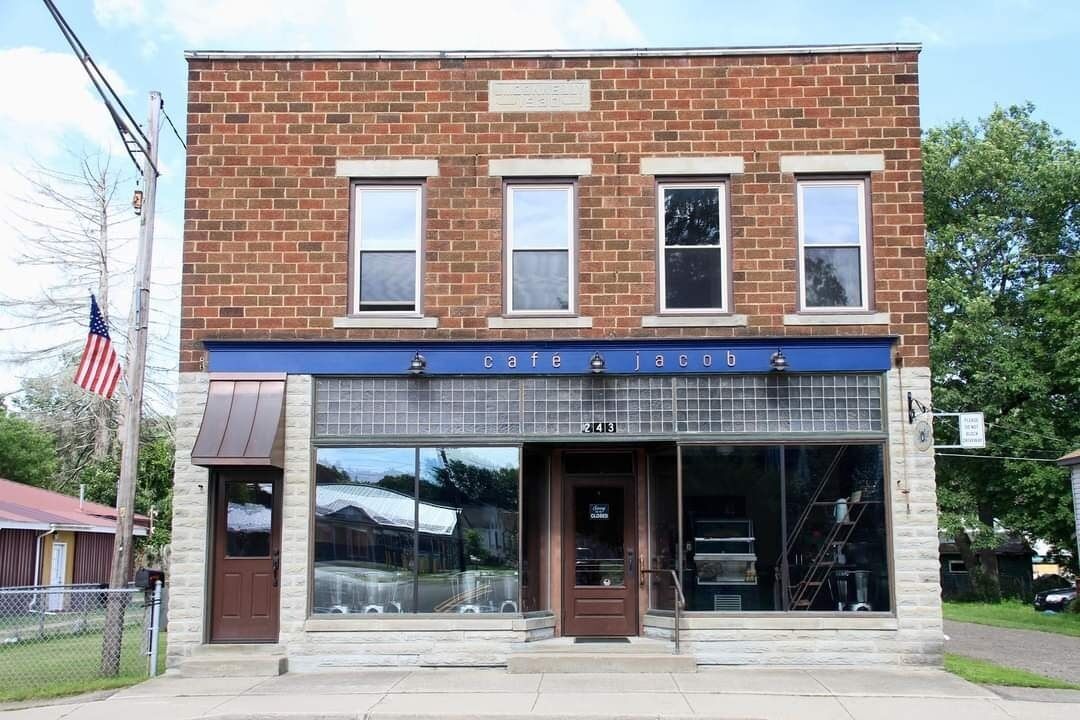 A two-story building with a brick facade and large windows.