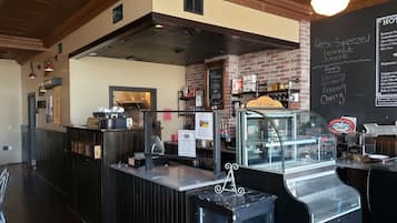 A cafe interior with a counter, a chalkboard menu, and a coffee machine.
