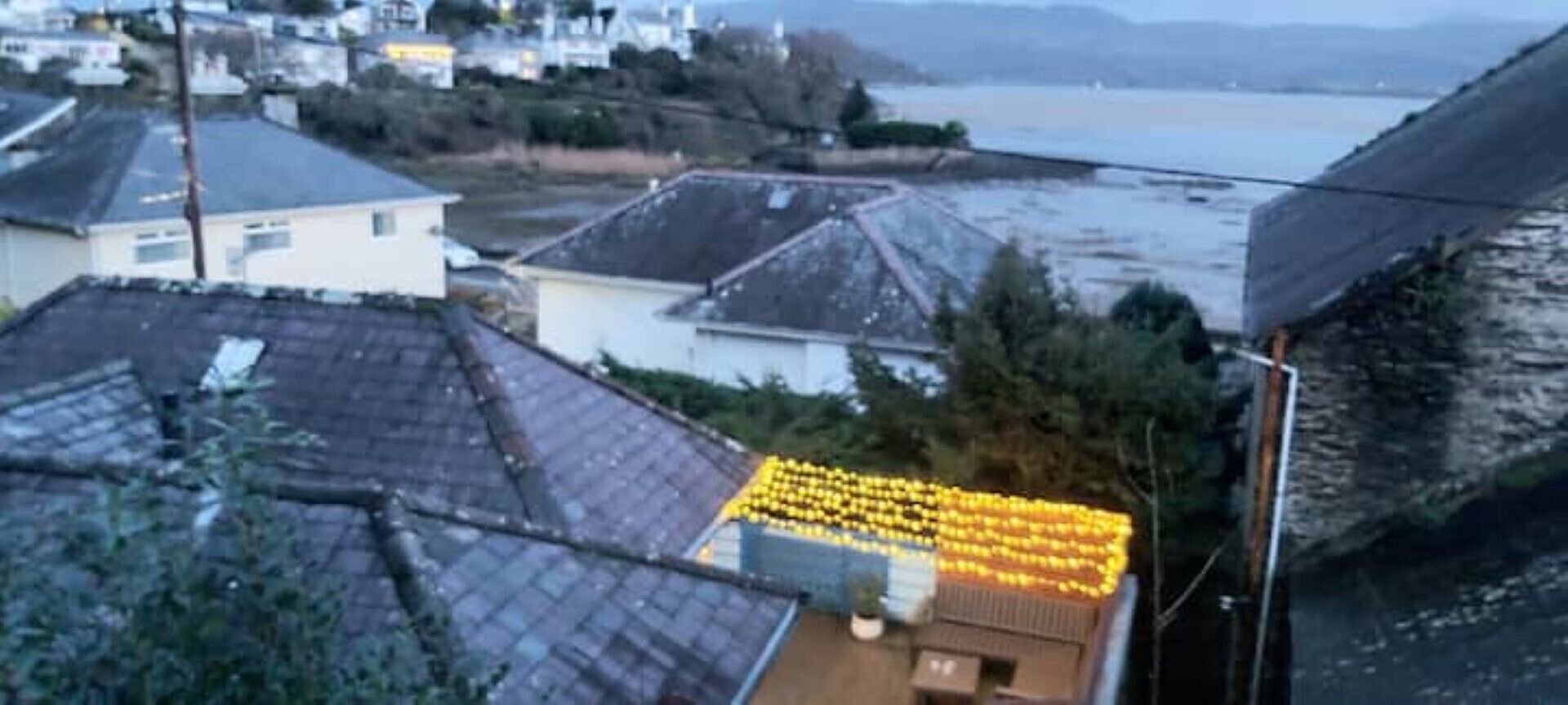 Un quartiere residenziale con case, una spiaggia e un litorale roccioso.