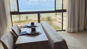 Un espace repas avec vue sur la plage et les palmiers.