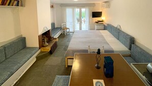 Uma sala de estar espaçosa com um amplo sofá, uma mesa de centro de madeira e uma televisão.