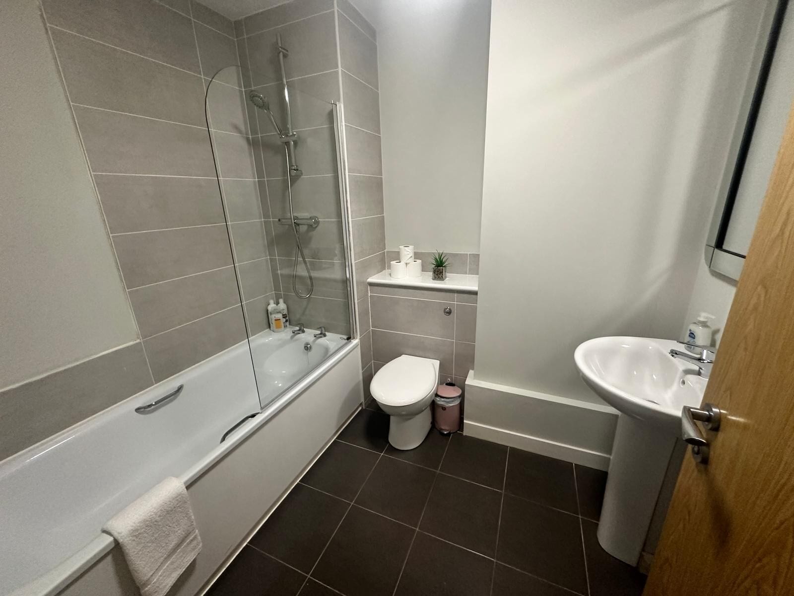 A modern bathroom with a bathtub, toilet, and sink.