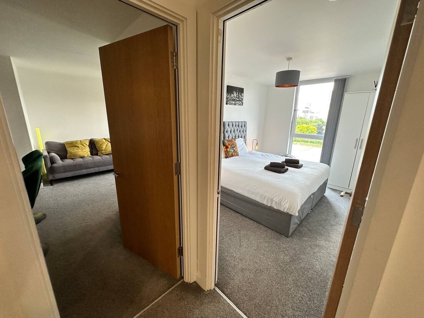 Un dormitorio con cama, sofá y vistas al exterior.
