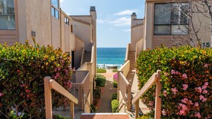 A staircase leading to a balcony with a view of the ocean.