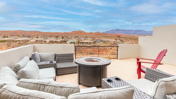 A rooftop patio with outdoor furniture, a fire pit, and a view of a desert landscape with mountains. - Zion Experience 4 Bedroom Townhouse by RedAwning (Washington)