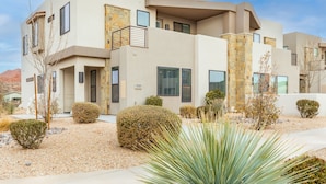A modern two-story house with a stone facade, multiple windows, and a well-maintained garden with various shrubs and a large yucca plant. - Zion Experience 4 Bedroom Townhouse by RedAwning (Washington)