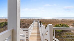 A wooden boardwalk leading to a beach with a clear sky. - Fish-n-chips By The Sea 6 Bedroom Home by RedAwning (Supply)