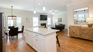 A spacious kitchen with a large island, wooden cabinets, and pendant lighting. - Great Location! 4 Bed / 4.5 Bath House in Pinehurst! (Pinehurst)