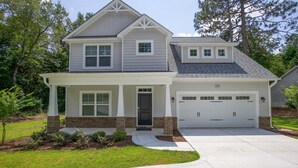 A two-story house with a garage, a covered porch, and a well-maintained lawn. - Great Location! 4 Bed / 4.5 Bath House in Pinehurst! (Pinehurst)